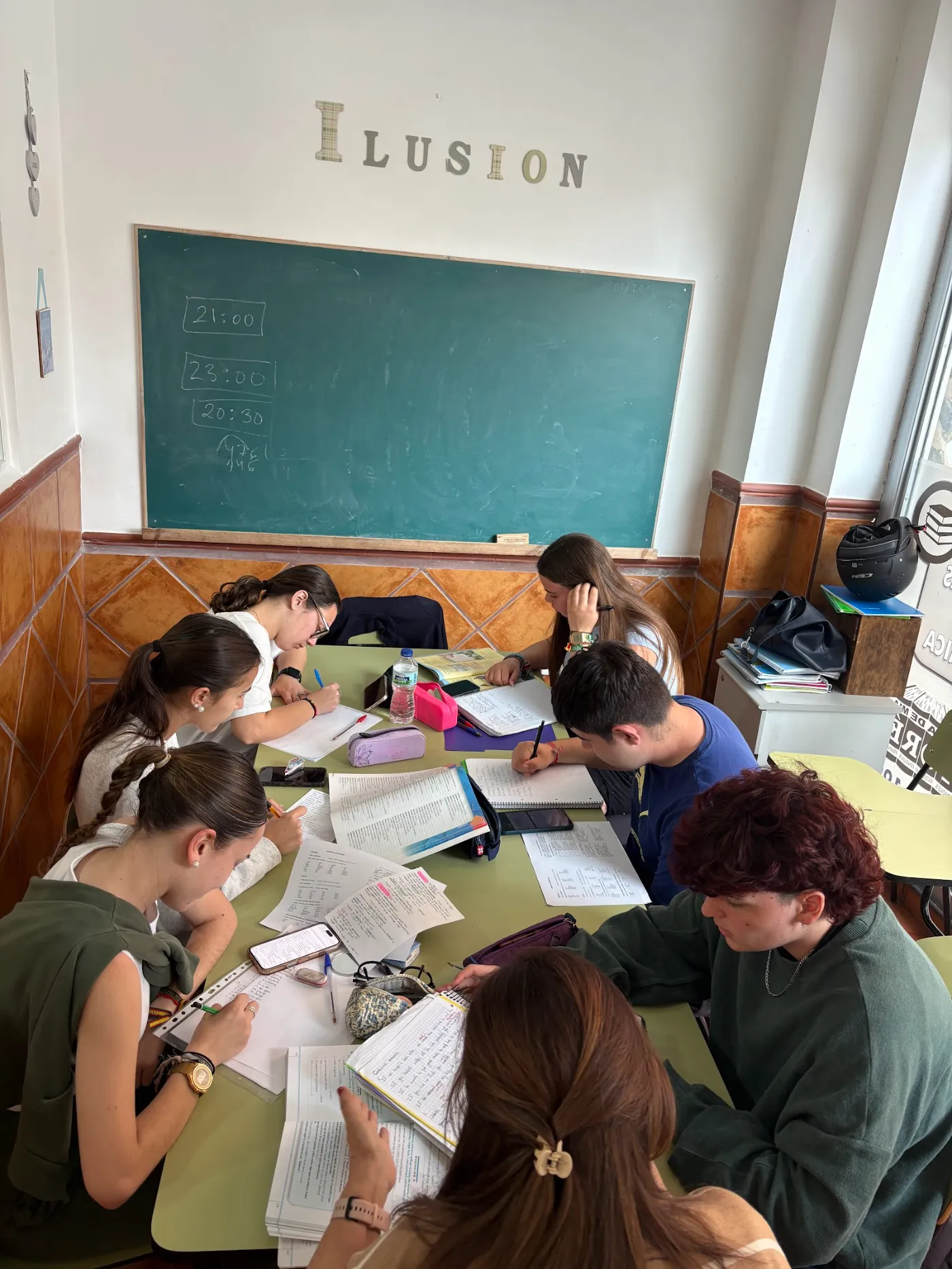 Alumnos de Bachillerato estudiando juntos en un aula de Academia Toré, bajo la palabra «Ilusión» escrita en la pared