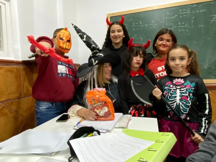 Alumnos y profesora disfrazados en Halloween delante de una pizarra con límites